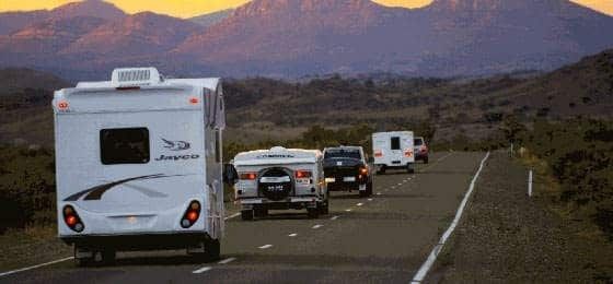 Caravanes et camping-cars roulant sur une route de montagne